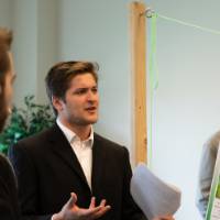 Two students interact in front of a poster